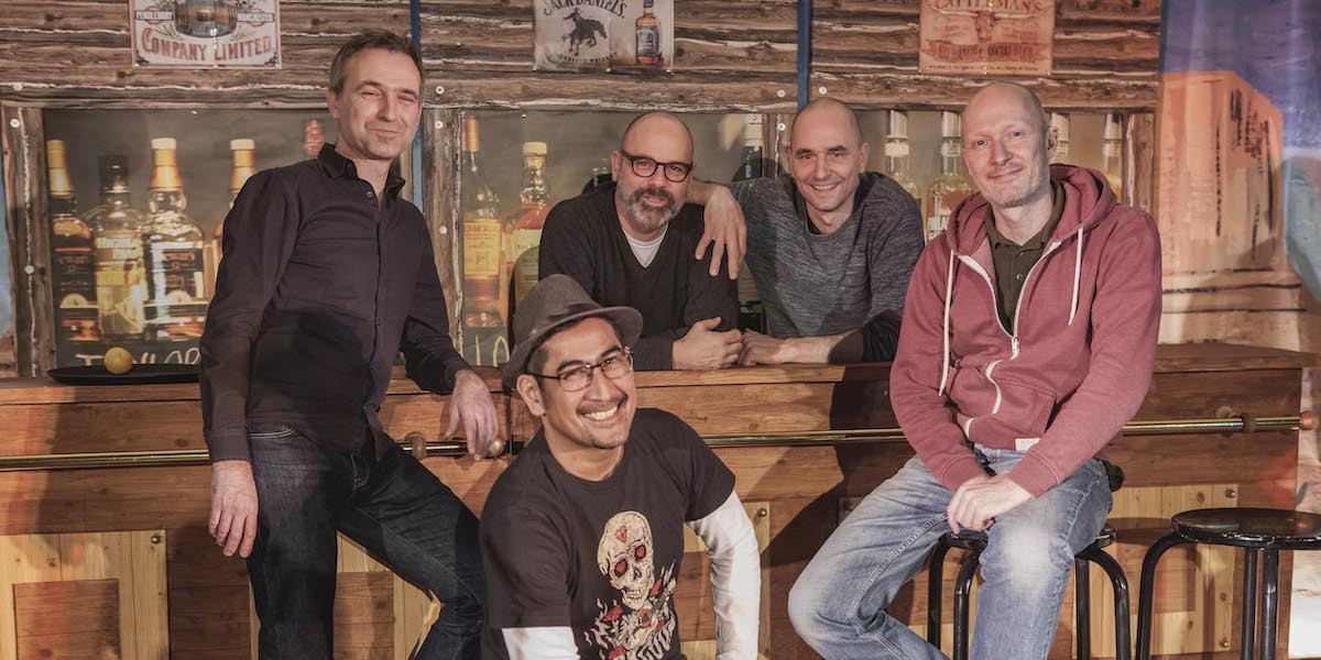 Die Corduroy Bande in der Kulisse des Theaterstücks, eine Westernbar